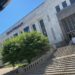 Picture of a large white building. A large wide staircase leads up to doors. Large black letters say, "Frist Art Museum". There is a wide but short green tree in front of the building.