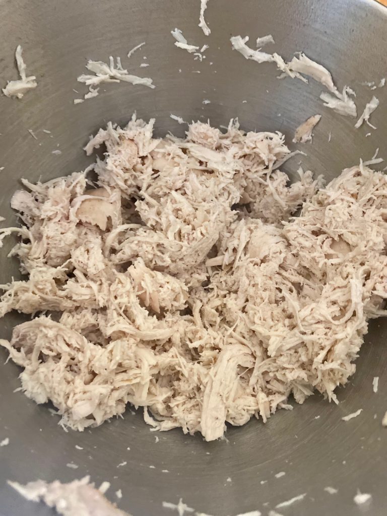 Shredded chicken in a silver bowl