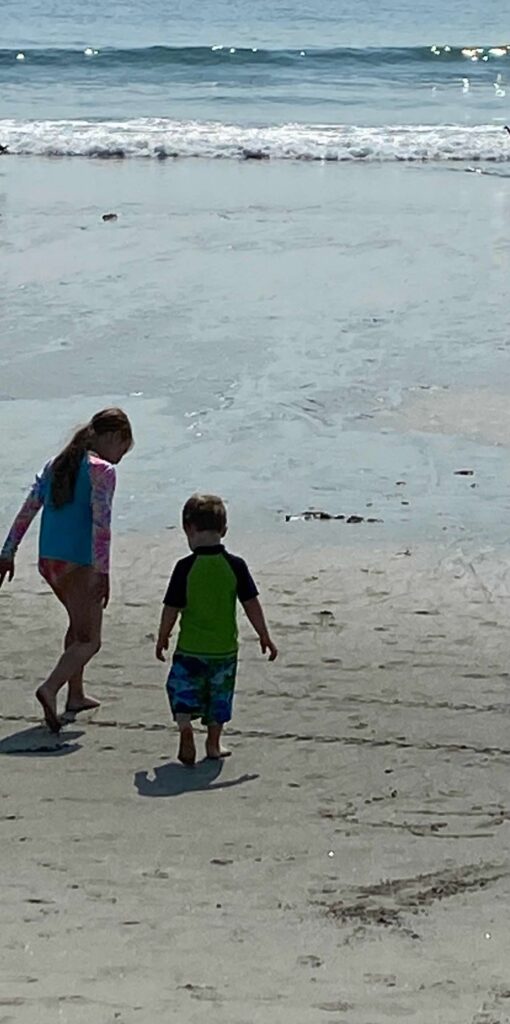 Two children enter the ocean at Hampton Beach