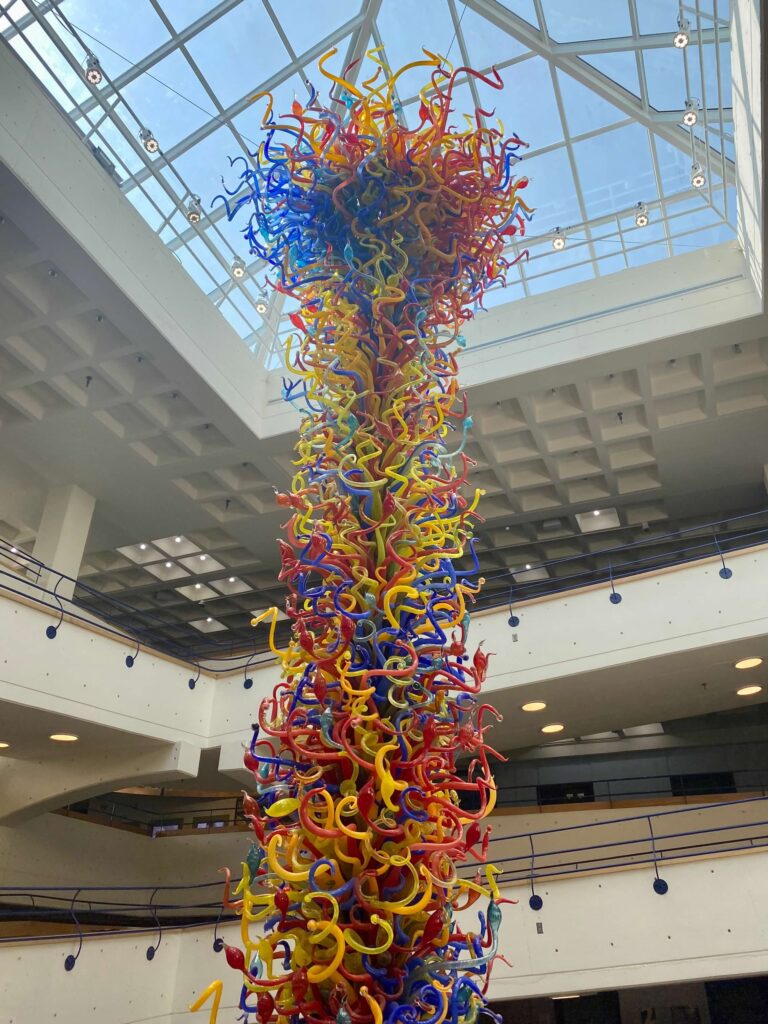 Multicolored glass pieces that look like ribbons curled and spiraling float down the center of the Children's Museum of Indianapolis