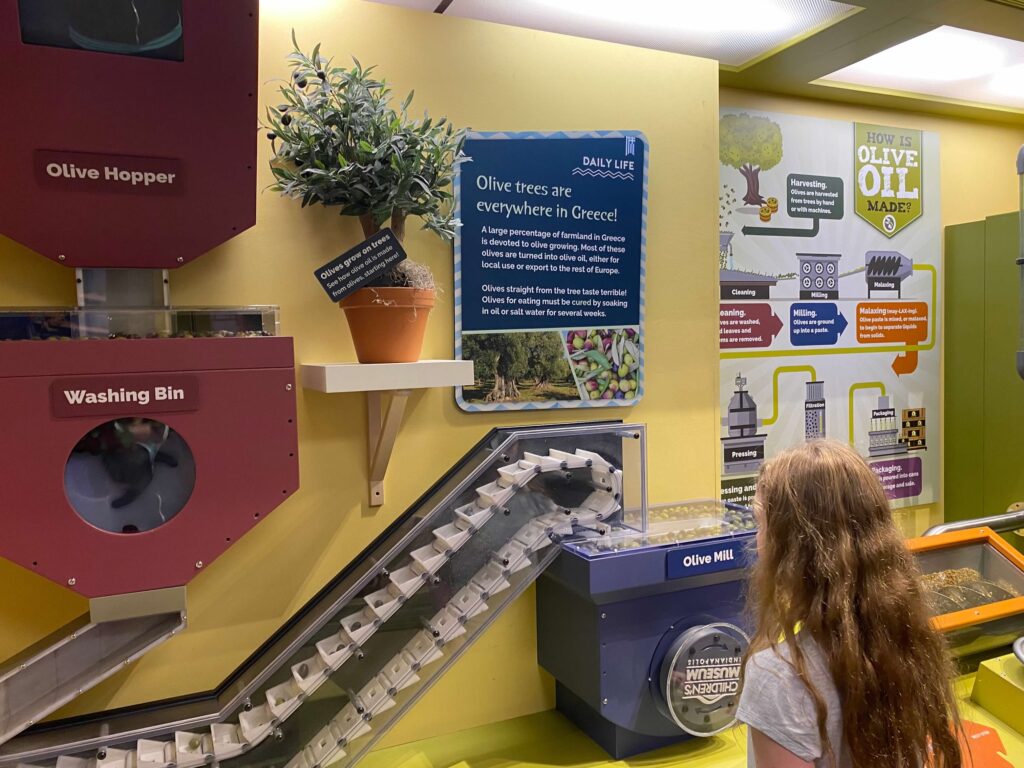 A child looks at a production model of olive oil in Greece in the Children's Museum of Indianapolis.