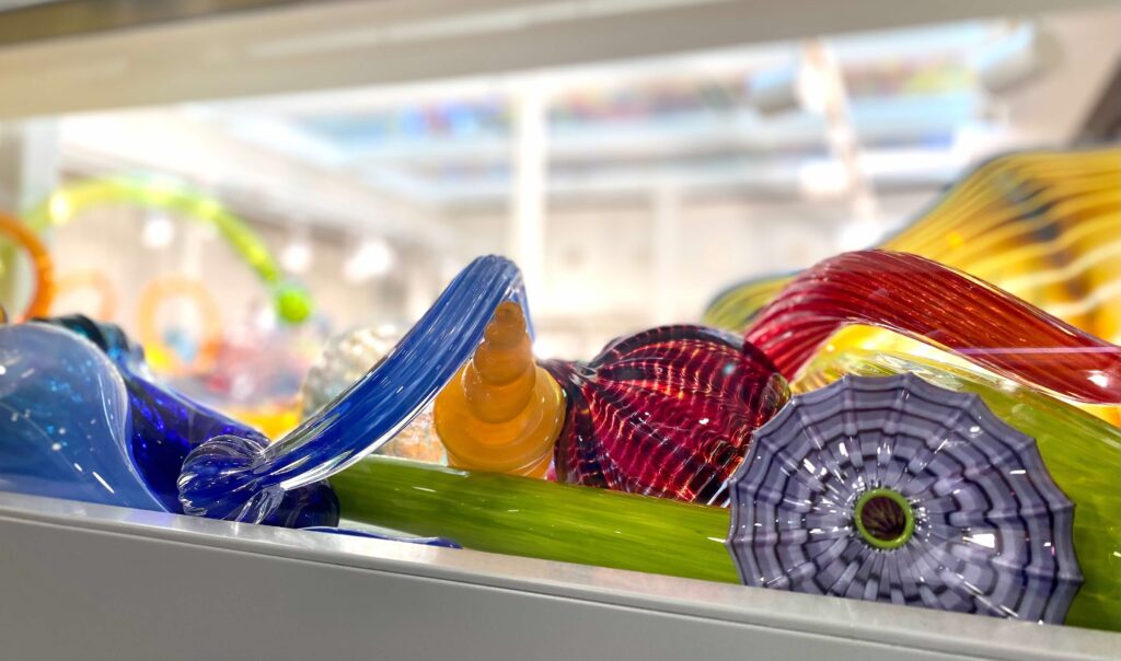 A close up of the multicolored ribbon-like glass sculpture of Dale Chihuly on shelf in the Children's Museum of Indianapolis