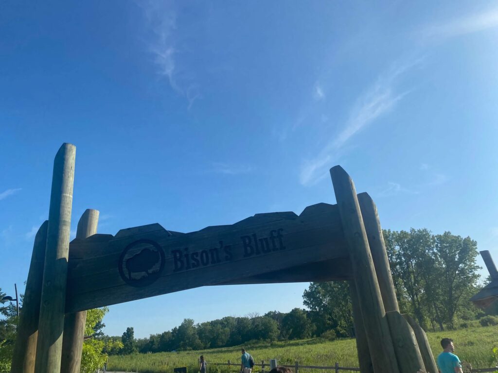 A large archway reads, "Bison's Bluff". There is a blue sky in the background as well as green grass. (Schaumburg, Illinois)