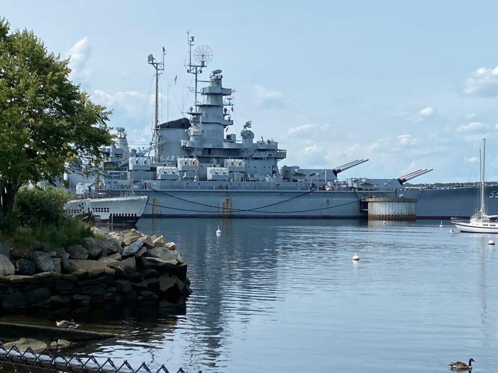 A battleship is in the water at Battleship Cove. 